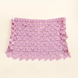 Close-up of pink heart sequins and metal ring mesh on a stylish body chain skirt