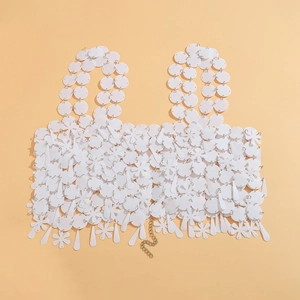 Detalle de la cadena corporal de lentejuelas blancas con flores y eslabones metálicos