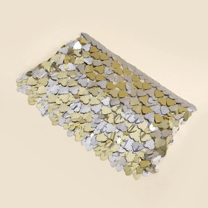 Detailed macro view of gold and silver heart-shaped sequins linked by metal rings