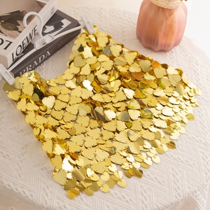 Macro shot of gold heart-shaped sequins connected by metal rings in a mesh design