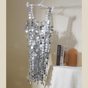Detalle de vestido de lentejuelas plateadas hecho a mano con anillos de metal floral