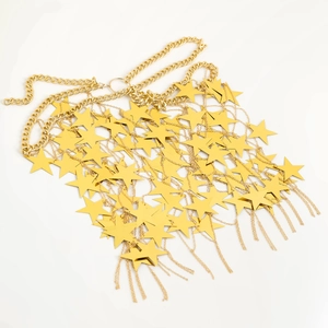 Dettaglio della catena corpo dorata con paillettes a stella lucide e maglie catena groumette