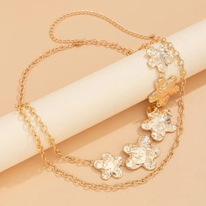 Detail of golden floral waist chain with hammered texture on minimalist prop