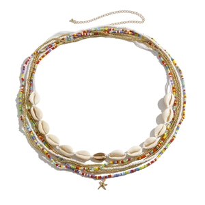 Detail van bohemien tailleketting met gekleurde kralen, schelpen en gouden zeester hanger