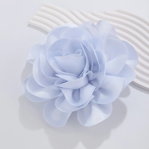 Detail of light blue satin fabric rose brooch with multi-layered petals and pearl luster
