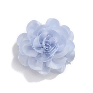 Detailed macro view of light blue satin fabric flower with layered petals and silk texture