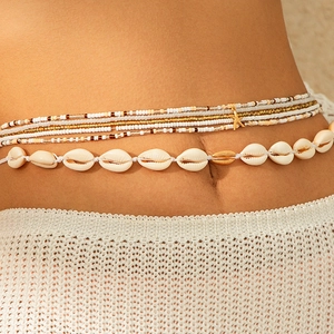 Detail van bohemien schelp tailleketting en kralenlagen met letter A-hanger