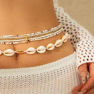 Detail of bohemian waist chain featuring natural shells and golden starfish pendant charms