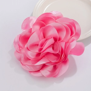 Detailed macro view of vibrant pink satin fabric flower with layered petals and silk texture
