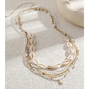 Detail showing multi-layer beach waist chain with white beads, shells and starfish charms