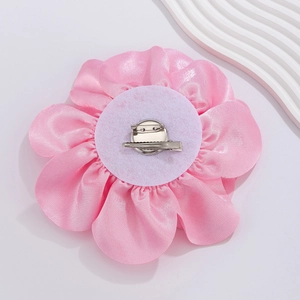 Detail view of pink satin flower brooch with silver dual-use hair clip and safety pin