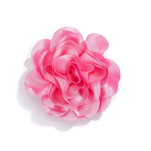 Detailed close-up of a handmade pink satin fabric rose brooch with layered petals