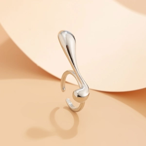 Detailed macro view of an irregular silver teardrop ring with a liquid lava metal texture