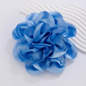 Macro view of blue satin rose brooch showing detailed fabric texture and layers