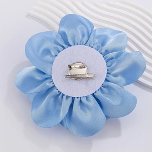 Detailed back view of light blue satin flower with dual safety pin and duckbill clip