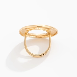 Macro view of golden hollow disk ring featuring detailed metallic cast textures
