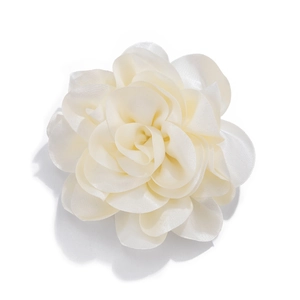 Macro view of white satin fabric flower brooch with multi-layered silk petals