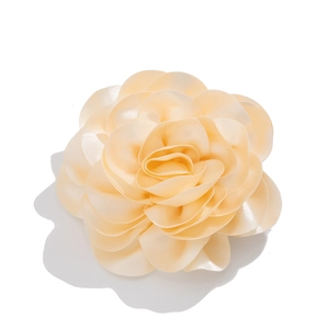 Close-up of layered satin fabric rose brooch showing champagne gold petal texture
