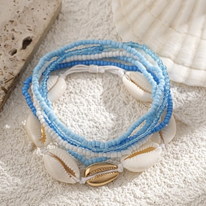Detailed close-up of blue beads and natural shells on a beach-style waist chain