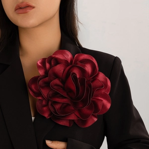 Elegant burgundy oversized satin flower brooch pinned to a dark suit lapel