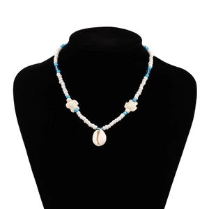 Detail of beach necklace featuring sea turtle charms and white shell pendant on a bust