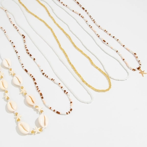 Macro detail of bohemian shell and starfish waist chains with golden beaded texture