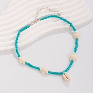 Detailed shot of ocean style turquoise beads necklace with sea turtle charms and cowrie shell