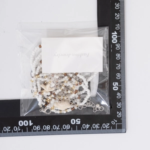 Détail d'une chaîne de corps à perles multicouches avec pendentifs étoile de mer et tortue