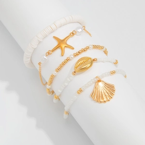 Close-up of four-piece beach bracelet set with starfish, seashells and gold beads