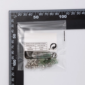 Detailansicht eines Vintage Libelle Stern Armbands mit grünen Steinen in Verpackung