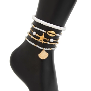 Macro shot of 5-piece beach anklet set featuring ocean shell and starfish charms