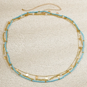 Detail of layered waist chain with sky blue seed beads, gold sequins, and white faux pearls