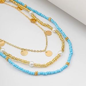 Close-up of layered bohemian waist chain with sky blue seed beads and golden sequins