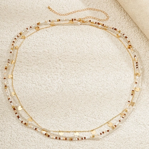 Detail of bohemian layered waist chain featuring gold sequins and colorful seed beads