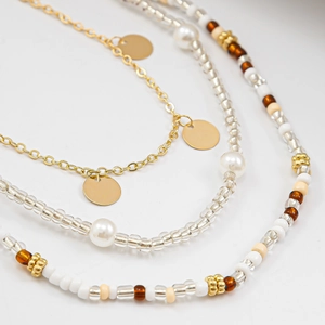 Detailed close-up of layered golden waist chain with colorful beads and white pearls