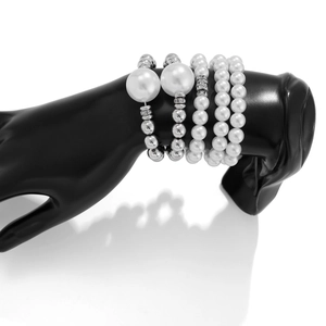 Detalle de set de 5 pulseras de perlas con cuentas plateadas y pedrería en el modelo