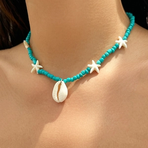 Close-up of bohemian beaded ocean necklace with turquoise beads and shell pendant