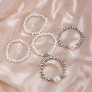 Ensemble de 5 bracelets en perles et billes d'argent sur fond de soie champagne