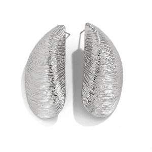 Detalle de la textura arrugada cepillada y el brillo metálico fluido de los pendientes plata