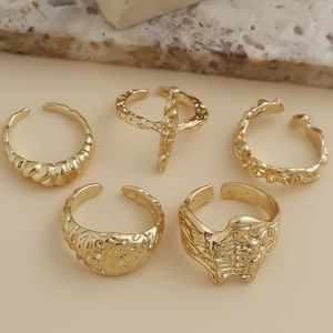 Detailed view of 5-piece gold lava texture and irregular geometric open ring set