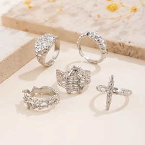 Detailed view of five silver lava texture rings set on natural stone with dry flowers