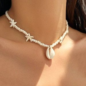 Close-up of beach necklace with white beads, starfish charms, and shell pendant