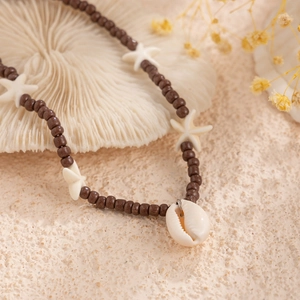 Detailed shot of bohemian bead necklace featuring dark brown beads with shell and starfish