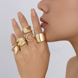 Close-up of golden irregular lava rings set showing metallic textures and wavy line design