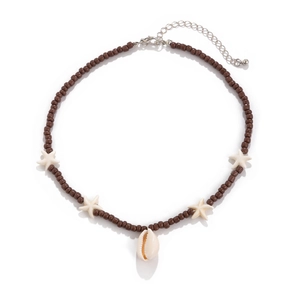 Detail of beaded beach necklace featuring dark brown beads, white starfish and cowrie shell