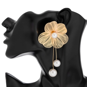 Detailed view of woven gold wire flower earrings with dangling pearl fringe accents
