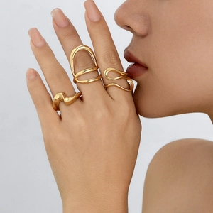 Nahaufnahme von unregelmäßigen goldfarbenen Ringen mit hohlem, geschwungenem Design
