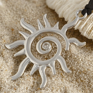 Primer plano de colgante de sol bohemio plateado con espiral en cordón negro