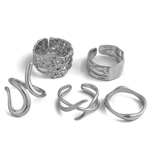 Macro shot of five-piece silver lava texture and irregular wavy metal rings set
