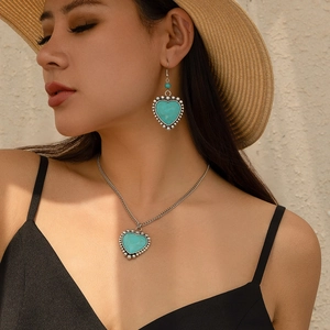 Boho-Set mit Herz-Türkis-Halskette und Ohrringen, präsentiert an einem Model mit Sonnenhut